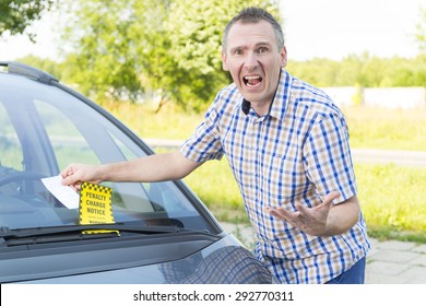 Suprised screaming man looking on parking ticket placed under windshield wiper