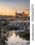 Sur District, Cordoba, Cordoba Province, Andalusia, Spain. May 1, 2023. Evening view of the San Rafael bridge and the Cordoba Cathedral.