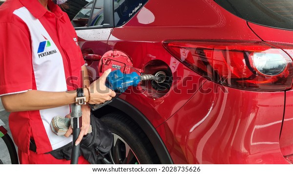 Surabaya, August 21, 2021: the process of\
refueling cars by officers at PERTAMINA\'s public gas stations. \
Pertamina \