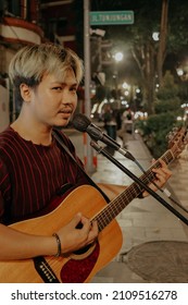 Surabaya, Indonesia - 9 Jan 2022 : Street Musician Singing While Playing Guitar At Night