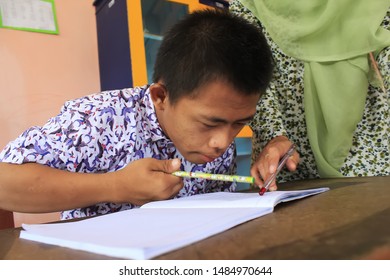 Surabaya - Indonesia. July 12, 2012. A Child With A Disability Is Learning To Write And Read In Class. Surabaya City Social Service Provides Special Place For Abandoned And Disabled Children To Be Fos