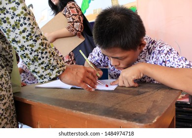 Surabaya - Indonesia. July 12, 2012. A Child With A Disability Is Learning To Write In Class. Surabaya City Social Service Provides Special Place For Abandoned And Disabled Children To Be Fostered Thr