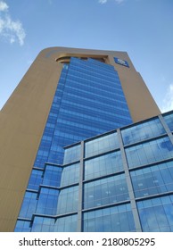 Surabaya, Indonesia - July 3 2022: Syariah Tower, Airlangga University, A Blue And Gold Tall Building Seen From Below In The Morning With Clear Sky