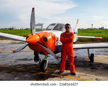 Surabaya, Indonesia - June 12, 2022: A Navy Pilot Poses In Front Of The Beechcraft Bonanza Plane On The Apron Of A Military Air Base