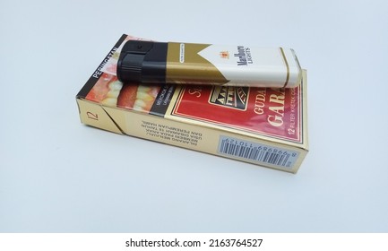 SURABAYA- INDONESIA, JUNE 4, 2022 : One pack of filters from the Gudang Garam Surya brand, one lighter, an original Indonesian product with a white background