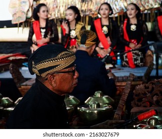 Surabaya, Indonesia - May 31, 2022: A man in a traditional Javanese costume is playing Gamelan, a famous traditional Javanese music instrument.