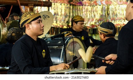 Surabaya, Indonesia - May 31, 2022: Men in traditional Javanese costumes are playing Gamelan, a famous traditional Javanese music instrument.