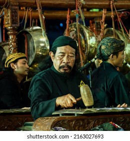 Surabaya, Indonesia - May 31, 2022: A man in a traditional Javanese costume is playing Gamelan, a famous traditional Javanese music instrument.