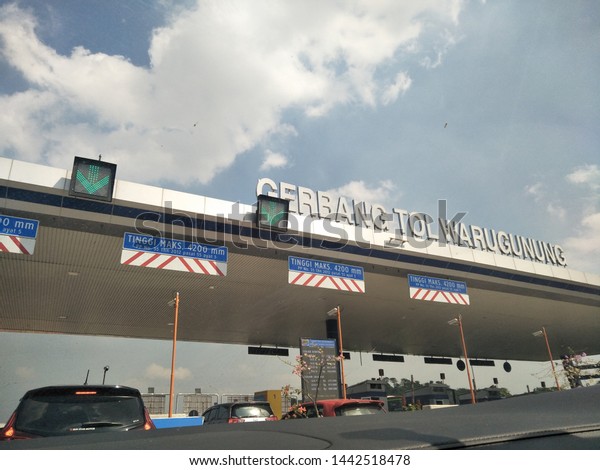 Surabaya, Indonesia - Translation in english: khusus\
special e toll vehicle volume 1, height maximum 2.1 m. Blue white\
sign board isolate on sky blue  clouds background with stop toll\
security bar