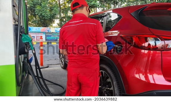 surabaya, september 4, 2021: red\
car is refueling Pertamax at Pertamina\'s public refueling\
point