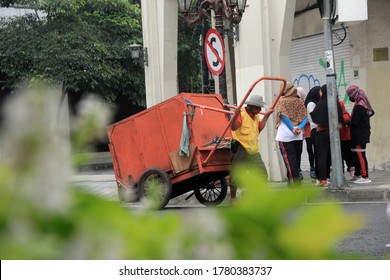 Surabaya-indonesia. July 19, 2020. A Janitor Was Carrying A Garbage Cart On The Highway. The Officer Cleaned Up The Rubbish By The Roadside