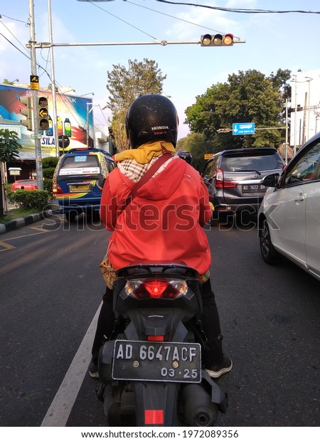 Surakarta, Central Java,\
Indonesia, May 10, 2021: pause for a moment because the traffic\
light is red