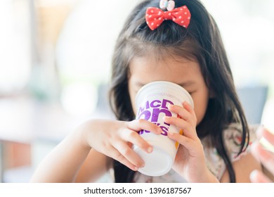 Suratthani, Thailand, May 11, 2019: McDonald's Soft Drink. Little Asian Girl Drinking Coke Coca Cola Drink In McDonald's Restaurant.