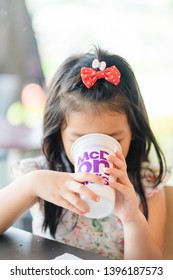 Suratthani, Thailand, May 11, 2019: McDonald's Soft Drink. Little Asian Girl Drinking Coke Coca Cola Drink In McDonald's Restaurant.