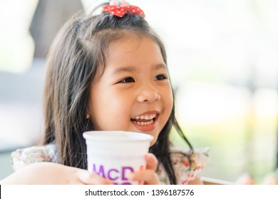 Suratthani, Thailand, May 11, 2019: McDonald's Soft Drink. Little Asian Girl Drinking Coke Coca Cola Drink In McDonald's Restaurant.