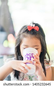 Suratthani, Thailand, May 11, 2019: McDonald's Soft Drink. Little Asian Girl Drinking Coke Coca Cola Drink In McDonald's Restaurant.