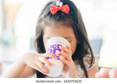 Suratthani, Thailand, May 11, 2019: McDonald's Soft Drink. Little Asian Girl Drinking Coke Coca Cola Drink In McDonald's Restaurant.