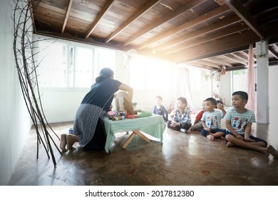 SURATTHANI,THAILAND - OCTOBER 30, 2017:Group of Asian kids sit and listen to teacher tell story with hand made Waldorf dolls,home schooler and waldorf school concept background.