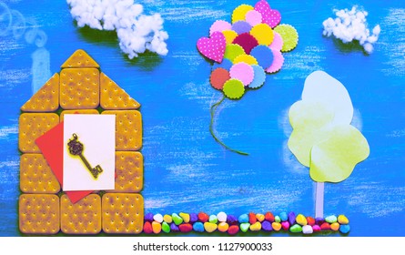 Surealism Concept Of A Cookie House On A Wooden Blue Sky Cloud Background Family Path. Top View Flat Lay