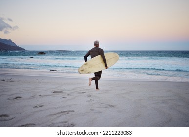 Surf at the beach, man and running to ocean with surfboard for the waves, fitness and adventure. Mature surfer at sunrise, in wet suit and to enjoy the sea, travel and summer on an island. - Powered by Shutterstock