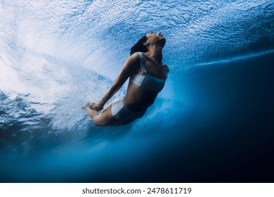 Surf girl dive underwater with ocean wave. Duck dive under barrel waves without surfboard - Powered by Shutterstock