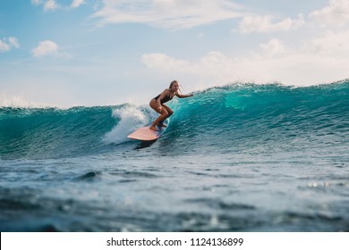 Surf girl on surfboard. Woman in ocean during surfing. Surfer and ocean wave