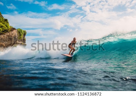 Surf girl on surfboard. Woman in ocean during surfing. Surfer and ocean wave