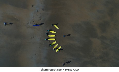 Surf instructor teaches surf students on a beach. - Powered by Shutterstock