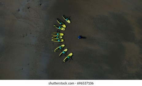 Surf instructor teaches surf students on a beach. - Powered by Shutterstock