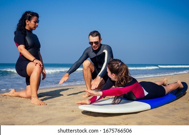 Surf Instructor And Two Girls Beginner Surfers On Lesson In Goa India