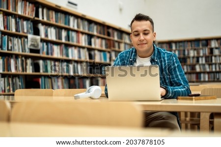 Surf the Internet in between classes. Student online lessons on the institute's website. Reads an e-book in the university library. A millennial man is studying at the institute.