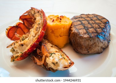 Surf And Turf Tenderloin Steak And Lobster Tail Grilled On A White Plate With Sweet Potato Mash