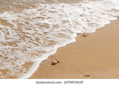 Surf wave is covering a sea beach sand - Powered by Shutterstock