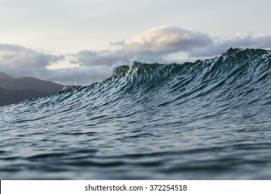 Surf/ a wave cresting and breaking on a surf beach 