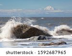 Surf zone on the beach in Kenai on the Kenai Peninsula with Mount Redoubt volcano in the Cook Inlet, Alaska, USA