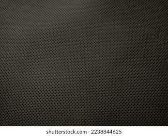 surface of black non-woven fabric as background and texture. Non-woven fabric with holes in the fiber and pores of the texture of the polypropylene fabric.