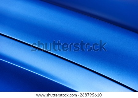 Surface of blue sport sedan car metal hood; part of vehicle bodywork 
