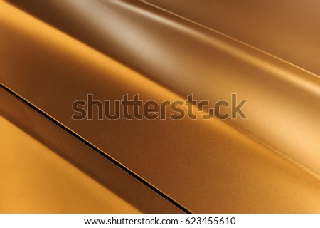 Surface of bronze sport sedan car metal hood, part of vehicle bodywork, steel gradient line pattern, selective focus