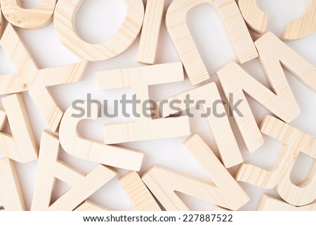Surface covered with multiple wooden letters as a background composition