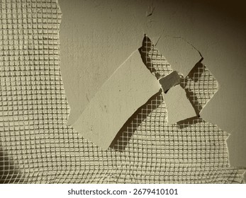 Surface damage reveals layers of texture on a wall in a construction site