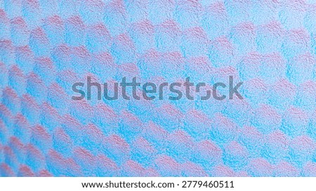 A surface displays a pattern of interconnected shapes in shades of blue and pink. The design creates a flowing effect in a creative space.