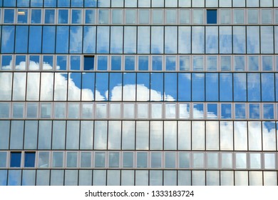 Surface of glass building with the reflection of clouds