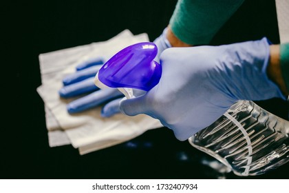 surface home cleaning spraying antibacterial sanitizing spray bottle disinfecting against COVID-19 spreading wearing medical blue gloves. Sanitize surfaces prevention in hospitals and public spaces. - Shutterstock ID 1732407934