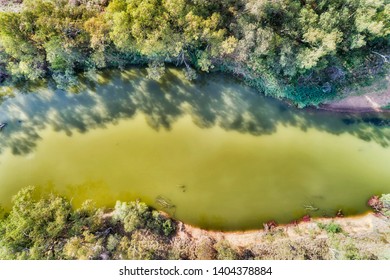 Surface Of Lazy Slow Gwydir River Between Gumtrees On Flat Banks In Moree Plains Area In NSW Outback. Aerial Top Down View Along River Stream.