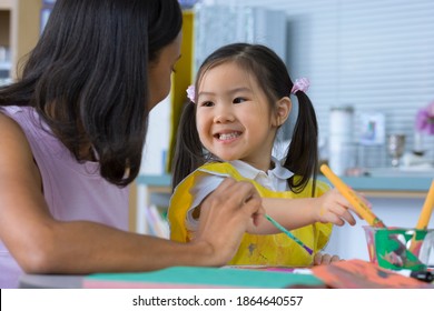 Surface Level Profile Shot Of A Girl Smiling At Her Teacher During An Art Class In A Classroom.