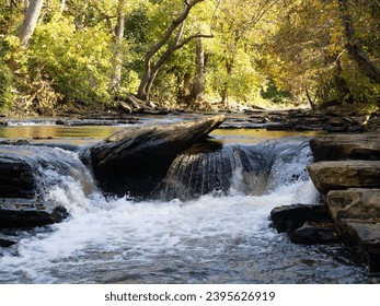 Surface level view of a small waterfall over boulders in Big Creek or Vickery Creek in the Chattahoochee River National Recreation Area in Roswell, GA
