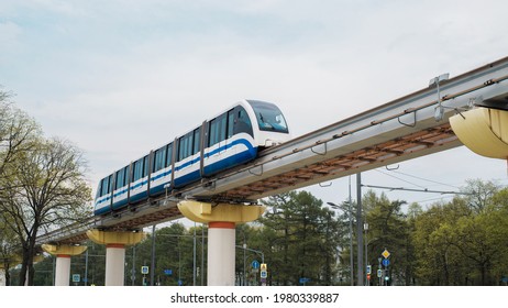 Surface metro. Modern train moving on rails above the ground in the city. Subway cars traveling across the bridge, outdoors. New public rapid transit