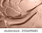 surface of oil or serum with bubbles. festive cosmetic background in mocha mousse color. Blurred background