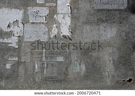 Surface of an old weathered bulletin board with remnants of torn paper ads, abstract grunge background texture, copy space