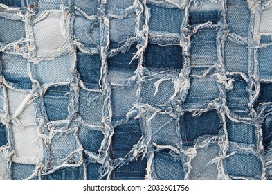 Surface of pieces of old tattered denim closeup